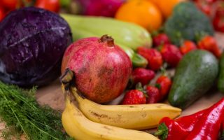 Grøntsager og frugt i mange farver bredt ud på et bord