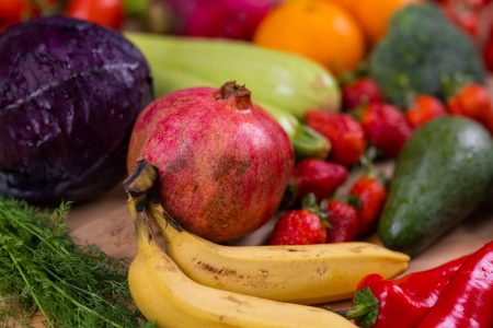 Grøntsager og frugt i mange farver bredt ud på et bord