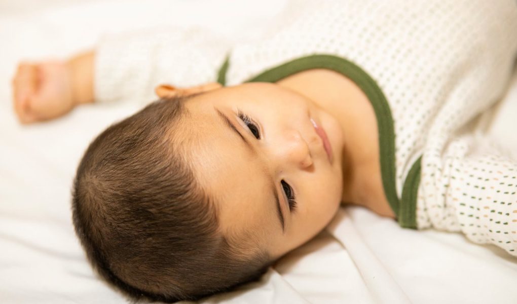 Smilende baby der ligger ned