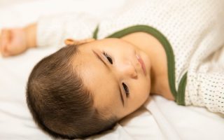 Smilende baby der ligger ned